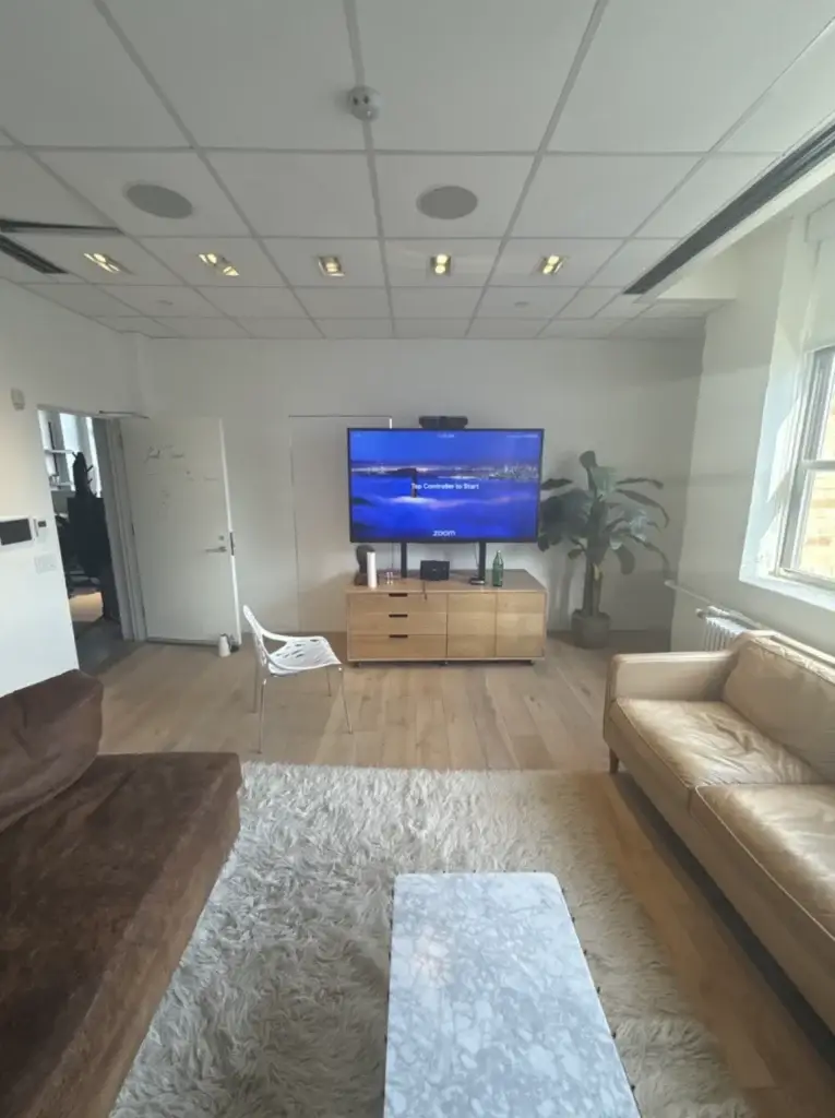 Ethic: A 65,000 sq ft Office, Fully Connected in Three Weeks 3 Ethic lounge-style Zoom Room with wall-mounted display and Logitech camera