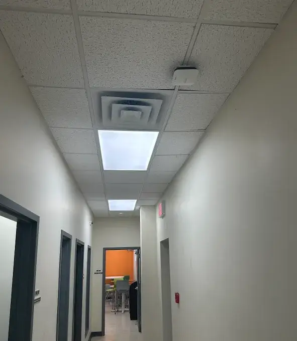Phipps: Cameras, Cabling and Wi-Fi Across 200+ Affordable Housing Properties 5 Ceiling-mounted Wi-Fi access point in a hallway at a Phipps property